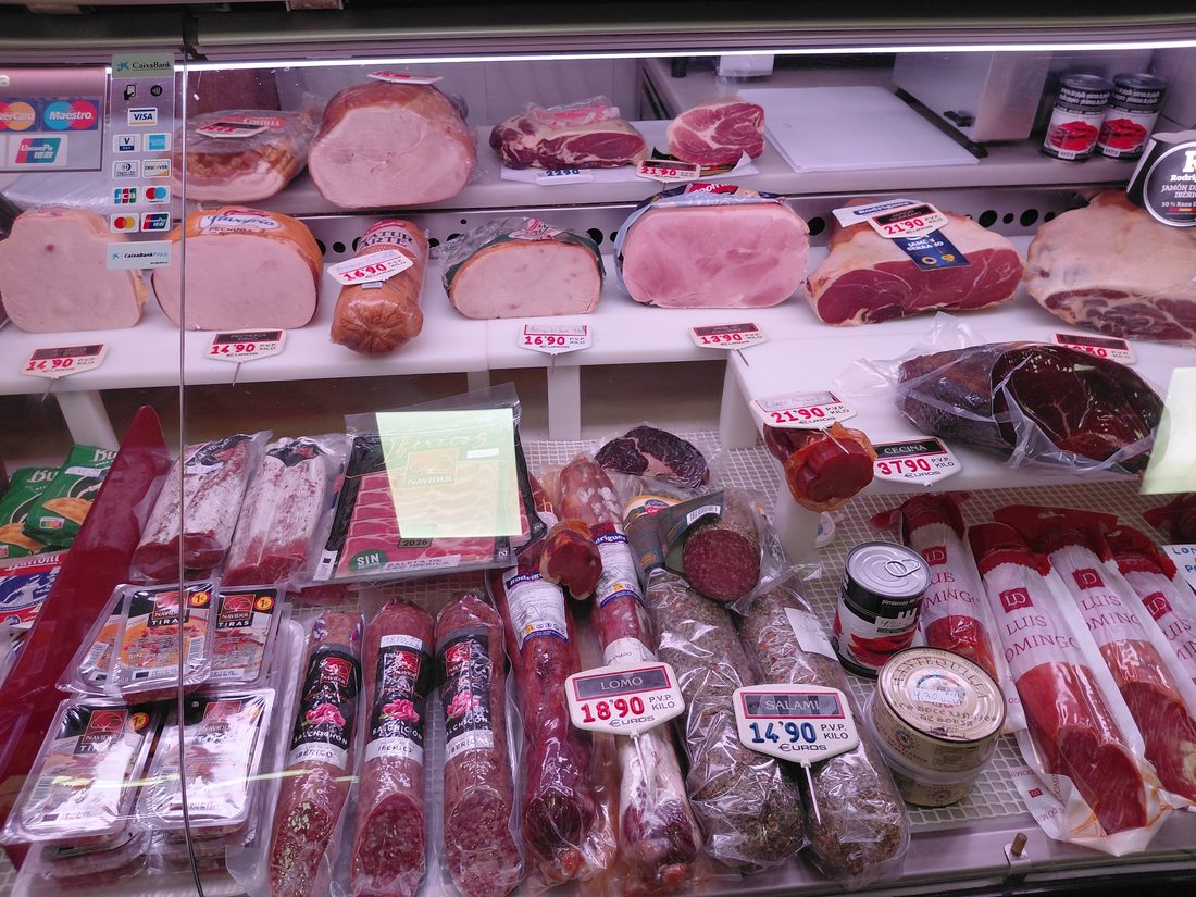 Jamones, paletas y curados ibéricos en el mostrador de Granja Luisa
